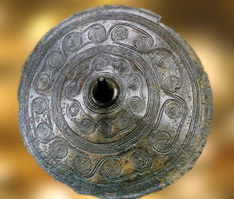 D'après un disque de ceinture, bronze, à enchaînement de spirales, Danemark, âge du Bronze. (Marsailly/Blogostelle)