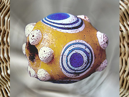 D'après une perle en pâte de verre colorée, à motifs circulaires et boules en haut relief, Picardie, France, Gaule celtique, âge du Fer. (Marsailly/Blogostelle)