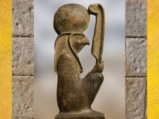 D’après le dieu Rê à tête de faucon, coiffé du disque solaire, brandissant la plume de la déesse Maât, figurine en bois, XVIIIe dynastie, Nouvel Empire, Égypte ancienne. (Marsailly/Blogostelle)